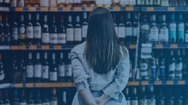 Femme cliente regardant un rayon de vin dans un supermarché